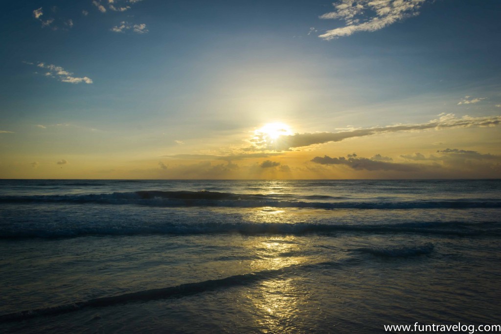 The sun setting over the waves in Tulum